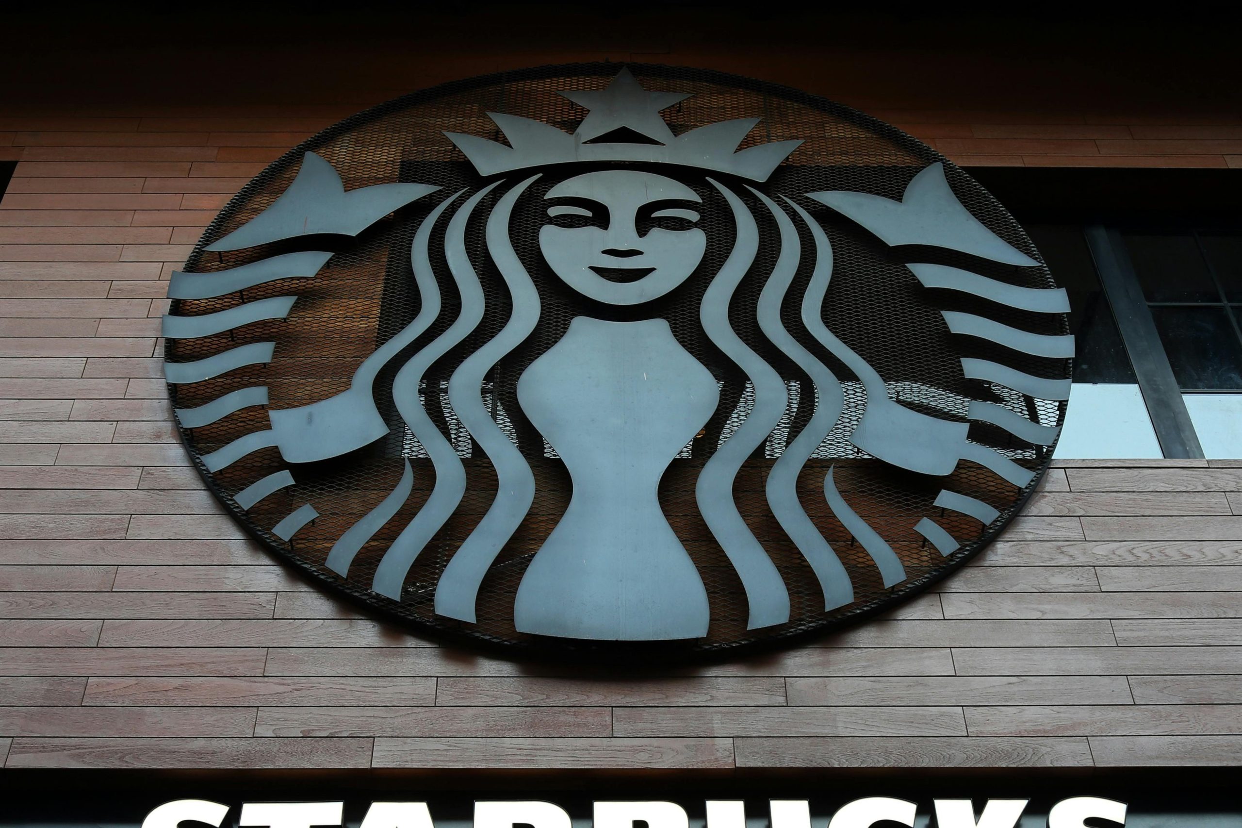 Low angle shot of Starbucks building exterior with logo and windows.