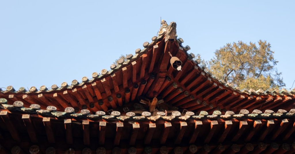 Close-up of a traditional Asian roof with intricate tiles and clear blue sky.